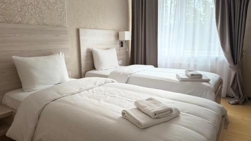 zwei Betten in einem Hotelzimmer mit Handtüchern darauf in der Unterkunft Anturazh Resort in Brody