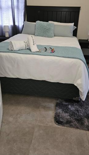 a bedroom with a large bed with a black headboard at 106 Barracuda Self-catering in Geneva