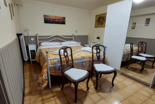1 dormitorio con 1 cama con 4 sillas en Locazione Turistica LBS, San Giacomo , Spoleto, en San Giacomo