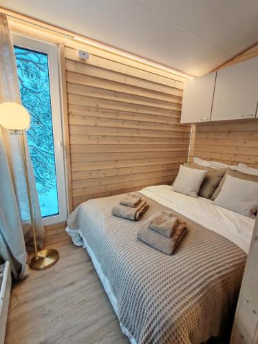 Villa Louhikko - Aavasaksa, Lapland في Aavasaksa: غرفة نوم بها سرير عليه منشفتان