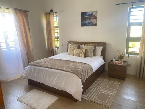 a bedroom with a large bed with white sheets and pillows at Villa Le Mahé, Mahébourg in Mahébourg