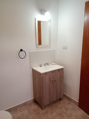 a bathroom with a sink and a mirror on the wall at Cabaña Avivando mi llama in Villa Giardino