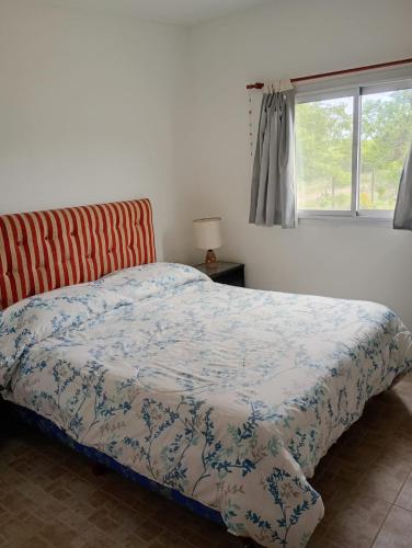a bedroom with a bed and a window at Cabaña Avivando mi llama in Villa Giardino