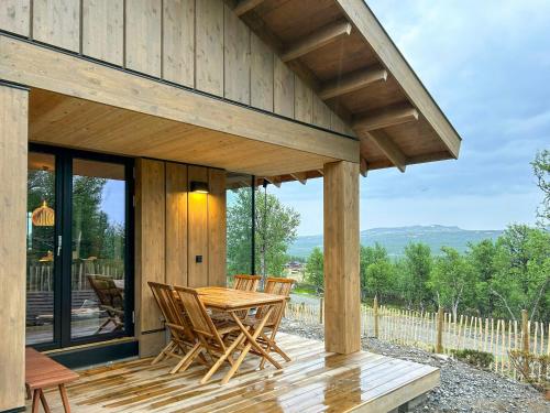 a wooden deck with a table and chairs on it at Modern Cabin By The Ski Trails At Fagerhøy in Sør-Fron