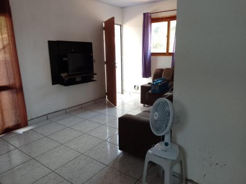 a living room with a couch and a tv on a wall at Casa em Ubatuba beach two in Ubatuba
