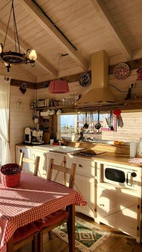 a kitchen with a table and a stove top oven at Tiny House Casuta Schiorului 2, Mărișel Apuseni in Mărişel
