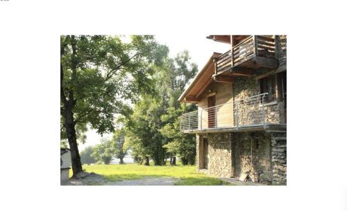 Un edificio con un balcón en el lateral. en Rustico Prato Grande con vista lago, en Carriola