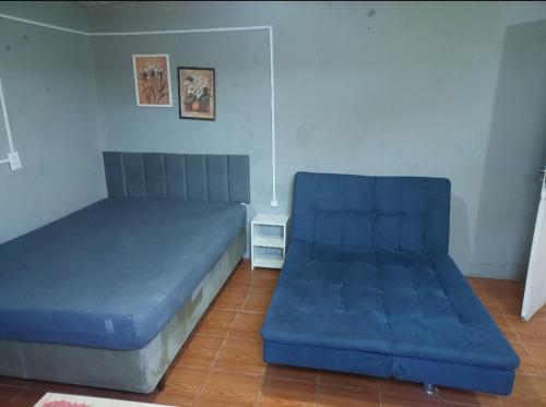 a bed and a couch in a room at Kitnet geminada próximo da praia in Torres