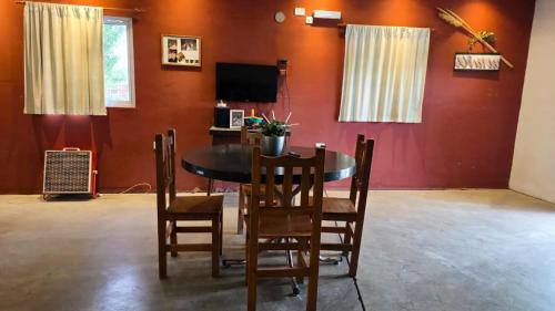 a dining room with a table and chairs and a television at Plumas verde, casa campo in Médano de Oro