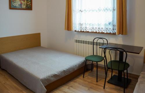 科尔别卢夫Dom w Górach Agro Zibi z zewnętrzną banią z jacuzzi的一间小卧室,配有一张床和一张桌子及椅子