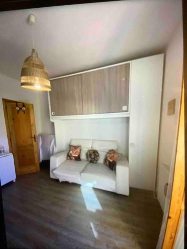 a living room with a white couch with pillows at A casa di Giulia in Filettino Graziani