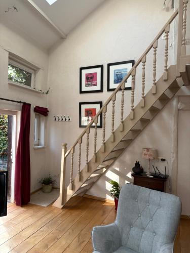 a living room with stairs and a chair at Vakantiehuis Rosa in Ons Belang