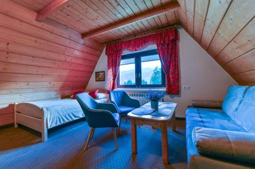 a room with a bed and a couch and a table at Dom Gościnny Efka in Kościelisko