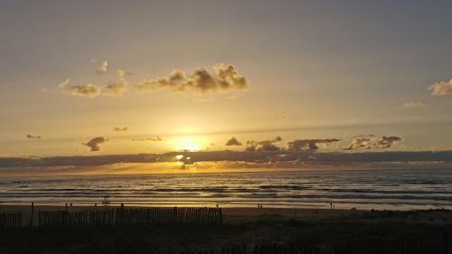 a sunset on the beach with the ocean at La Perle Aïn Diab Beachfront in Casablanca
