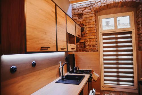a kitchen with a sink and a brick wall at Apartament Hallera in Chełmno