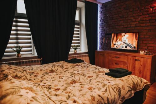 a bedroom with a bed and a brick wall at Apartament Hallera in Chełmno