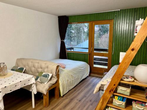 Studio près du lac في ماليبونسون: غرفة نوم بها سرير وأريكة ونافذة