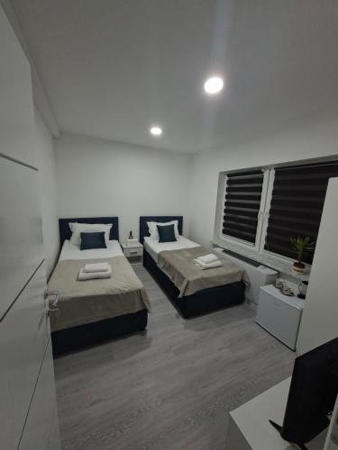 a bedroom with two beds and a window at Pansion Kod Brajlovica in Tuzla