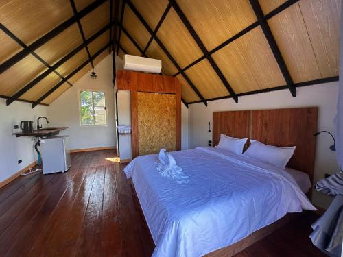 a bedroom with a large bed with a blue comforter at Phayam Paradise Resort in Ko Phayam