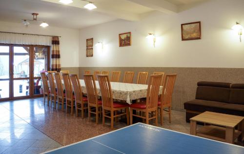 科尔别卢夫Dom w Górach Agro Zibi z zewnętrzną banią z jacuzzi的一间带桌椅和沙发的用餐室