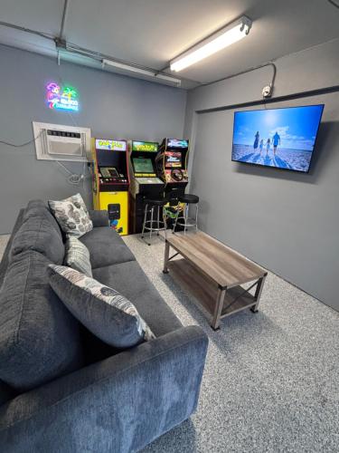 Oceanview Beach Retreat - Pool & Game Room - Steps to Beach - Sleeps 8 في كليرووتر بيتش: غرفة معيشة مع أريكة وألعاب فيديو