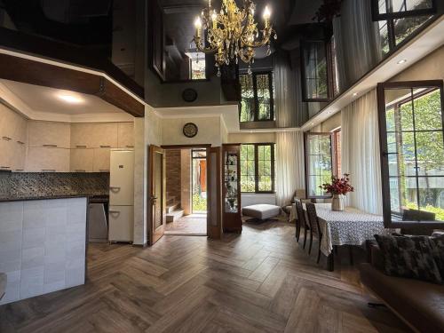 Villa Kolkhi في كفارياتي: مطبخ وغرفة طعام مع طاولة وثريا