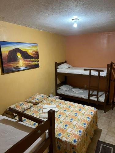 a bedroom with two bunk beds and a painting on the wall at Pousada Sol de Iracema Praia in Fortaleza