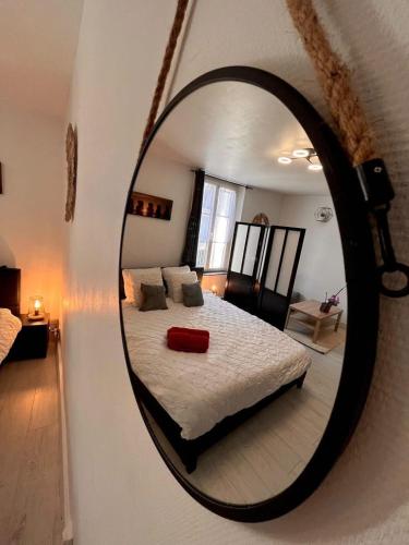 a mirror reflecting a bed in a bedroom at Cocon en vieille ville in Nancy