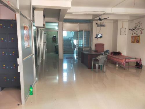 a living room with a couch and a table and a desk at Maa Tarini AC Dormitory in Balasore