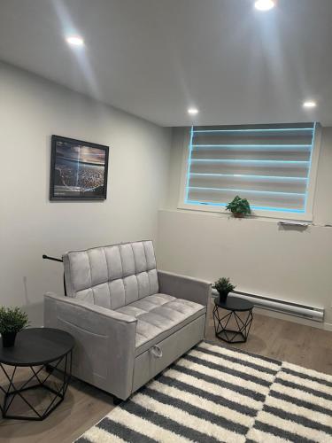 a living room with a couch and a window at Livingston Calgary Lovely space in Calgary