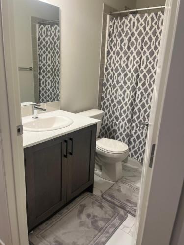 a bathroom with a sink and a toilet and a shower at Livingston Calgary Lovely space in YYC