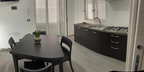 a kitchen with a table and a sink and a stove at BALISTRERI HOUSe in Trabia