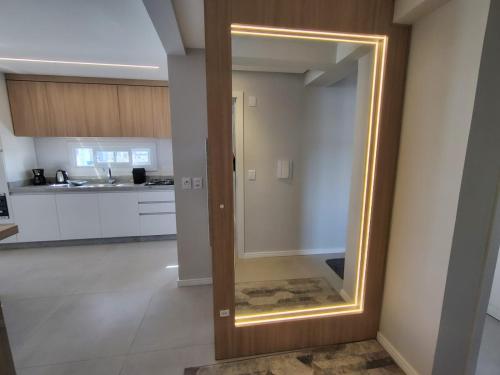 a large mirror on a wall in a kitchen at Praia e mar in Tramandaí