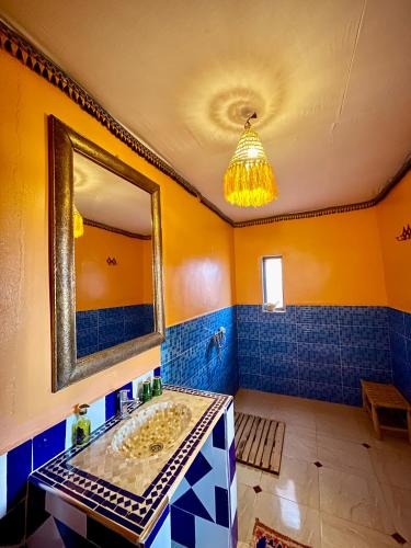 a bathroom with a sink and a mirror at Aladdin Desert Camp - Mhamid Erg Chigaga Escape in El Gouera