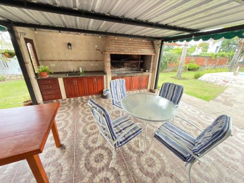 a patio with a table and chairs and a grill at Cabaña in Vaqueros