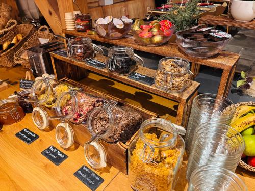 een tafel met veel glazen potten en andere etenswaren bij Typically Swiss Hotel Ermitage in Kandersteg