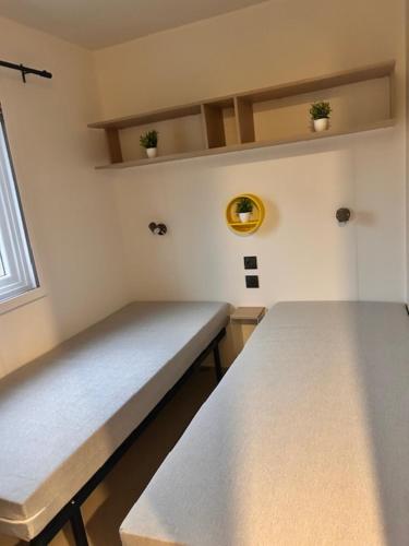 a bench in a room with two plants on the wall at Tinyhouse 6 Ferienwohnung Mobilheim Fehmarn in Fehmarn