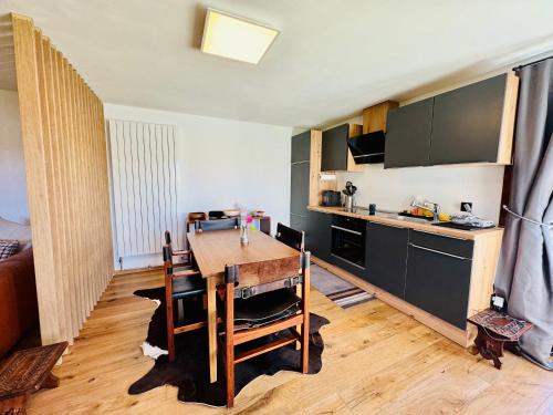 a kitchen with a wooden table in a room at Résidence La Rose du Le Ours, 2 Zimmer Idyll am See in LʼAbbaye