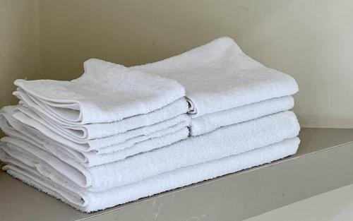 Loft con Luz Natural y Cocina Equipada في سالتيلو: كومة من المناشف البيضاء تقف على رف