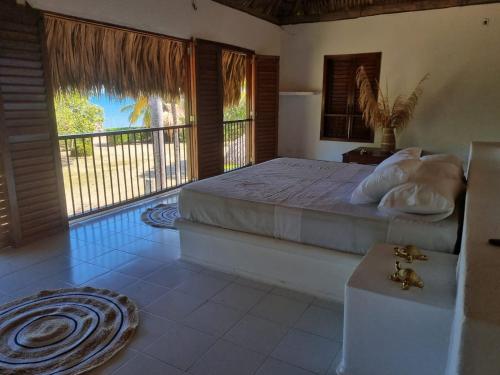 Un dormitorio con una cama y una ventana grande. en Hostal nido tortuga, en San Antero