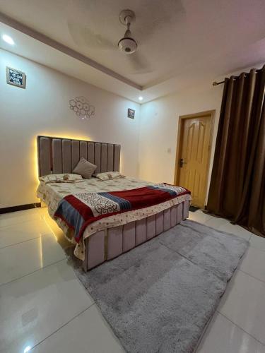 ein Schlafzimmer mit einem großen Bett in einem Zimmer in der Unterkunft Syed Apartment 302 in Islamabad