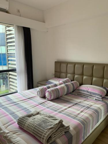 a bedroom with a bed with pillows and a window at Sky House BSD D2-3A - 3 Bedroom Type in Samporo