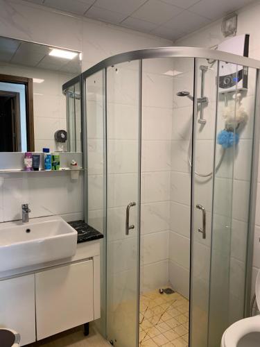 a bathroom with a glass shower and a sink at Sky House BSD D2-3A - 3 Bedroom Type in Samporo