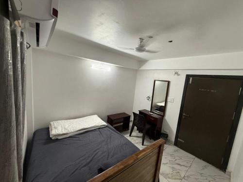 1 dormitorio con cama, espejo y puerta en S ROOMs, en Pithāpuram