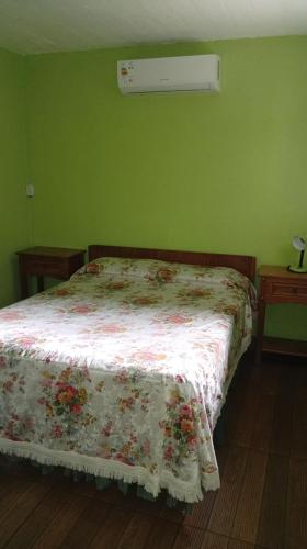 a bedroom with a bed with a floral comforter on it at LAPOSTa555 in Piriápolis