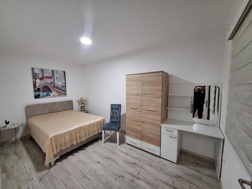 Un dormitorio con cama, escritorio y televisión. en Ris kuca za odmor, en Foča