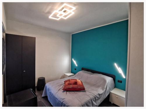 La Quintessenza في مونوبولي: غرفة نوم بها سرير وجدار أزرق