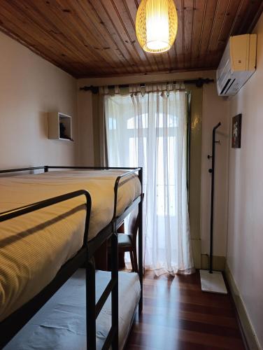 a bedroom with two bunk beds and a window at Casa do Pelourinho in Coja
