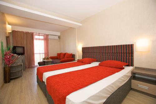 a hotel room with a large bed and a couch at Hotel Kotva - All Inclusive in Sunny Beach