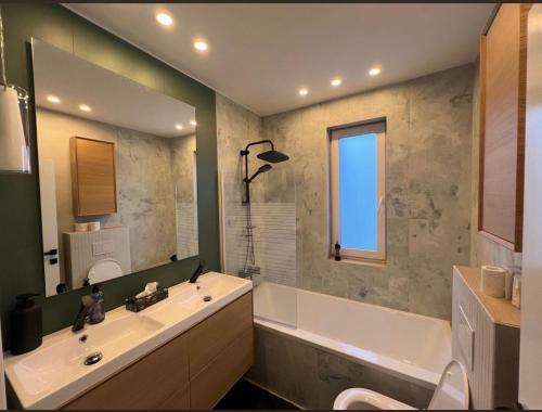 ein Badezimmer mit Badewanne, Waschbecken und Spiegel in der Unterkunft David’s place in Floreşti